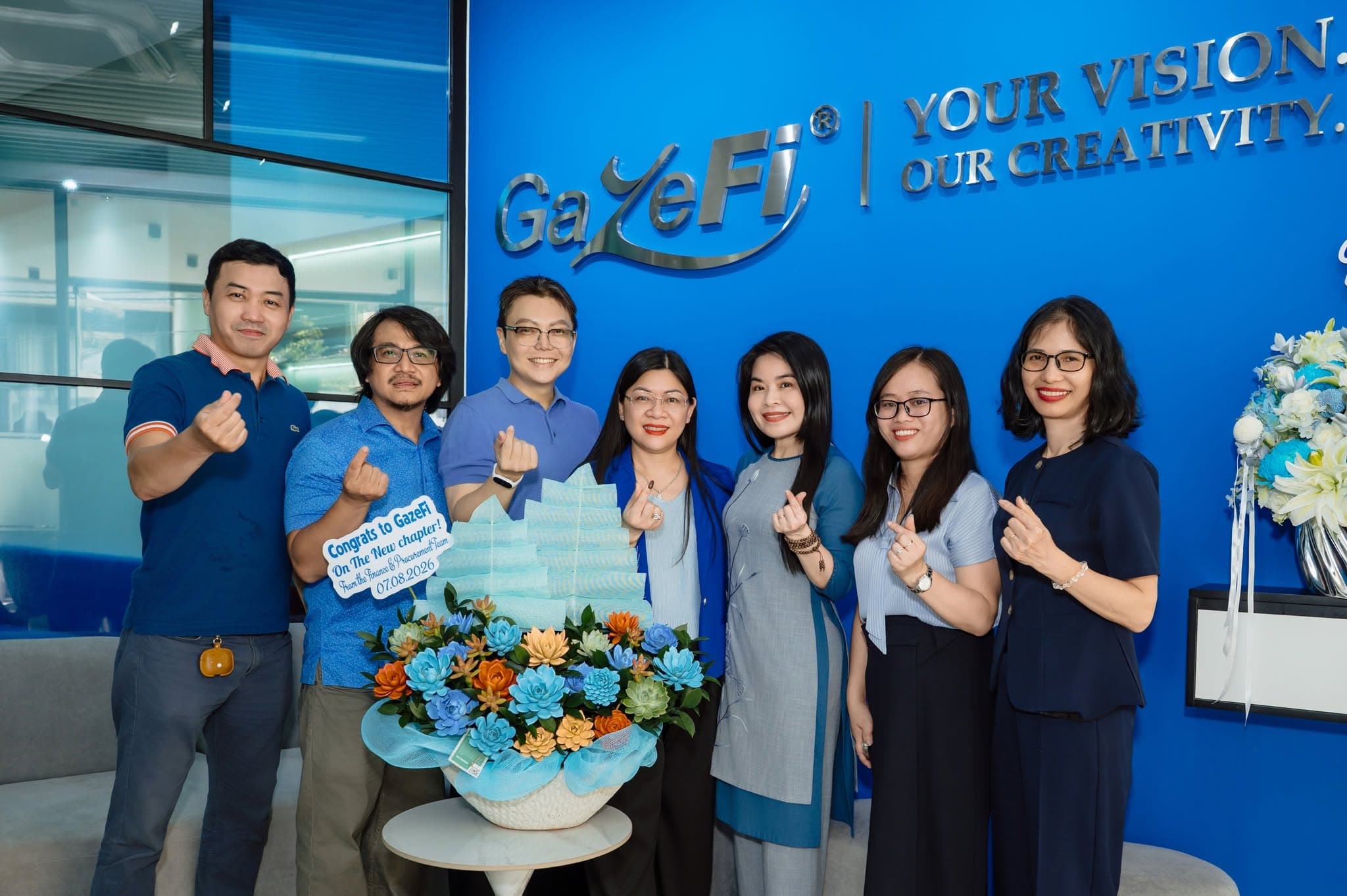 GazeFi team celebrating at the brand wall.